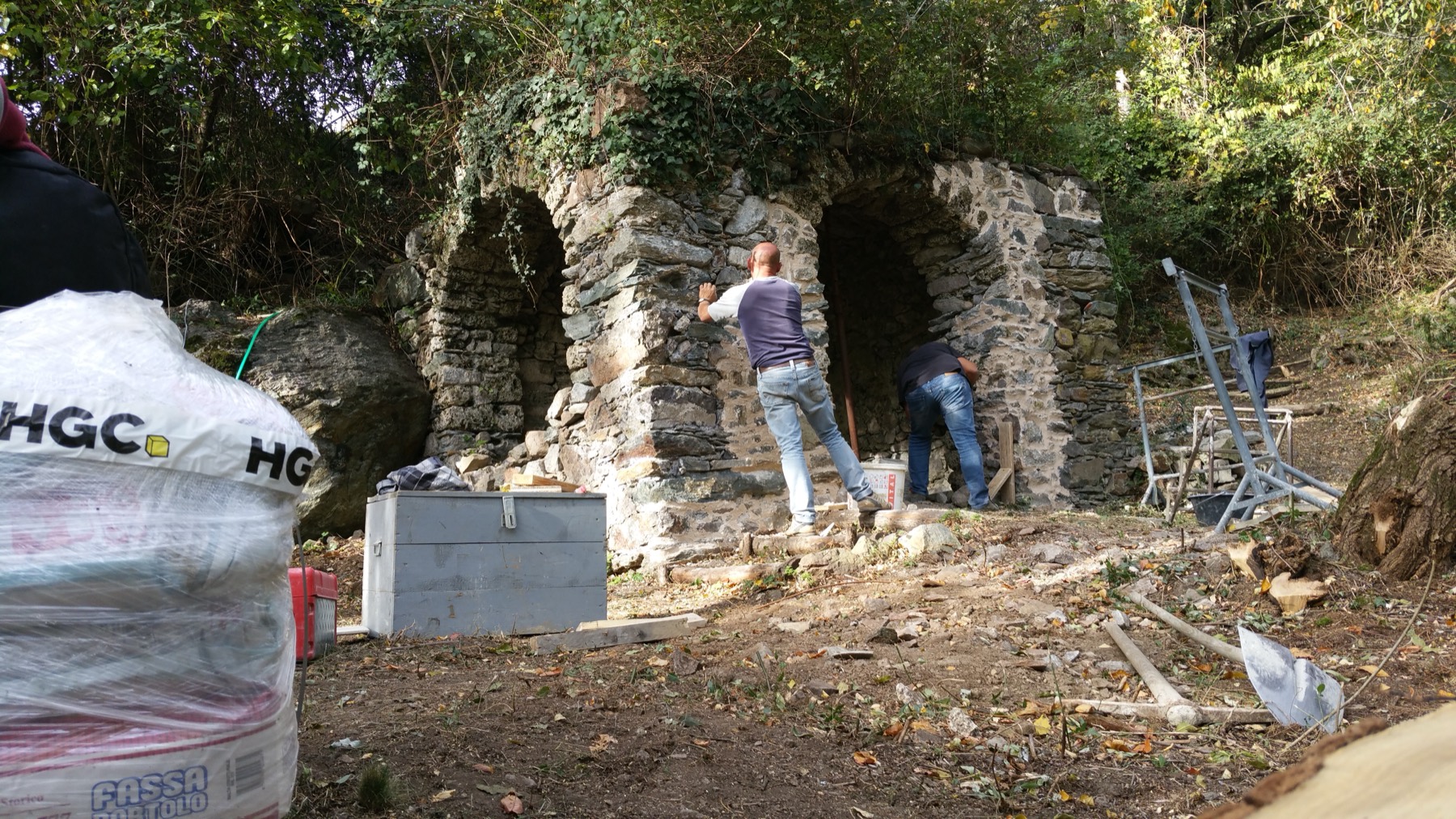 Operai impegnati nel consolidamento delle mura in pietra e degli archi della cappella in restauro, ottobre 2017